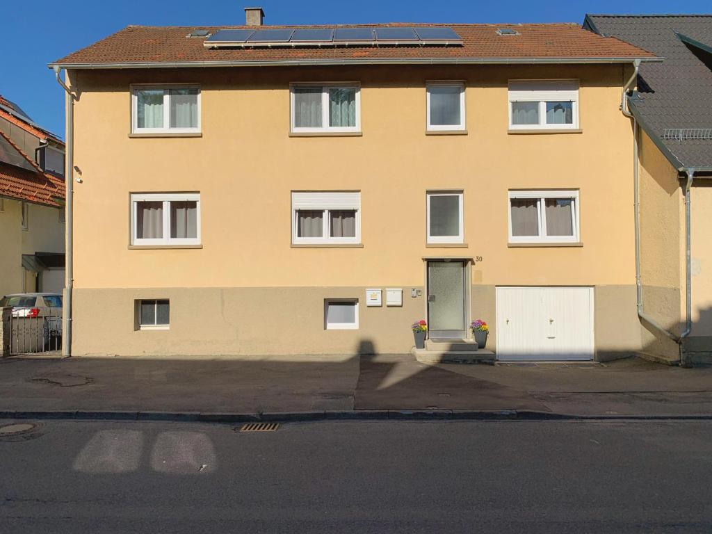 a yellow house with a white door and a street at Monteurzimmer/ Ferienwohnung Kati in Albstadt