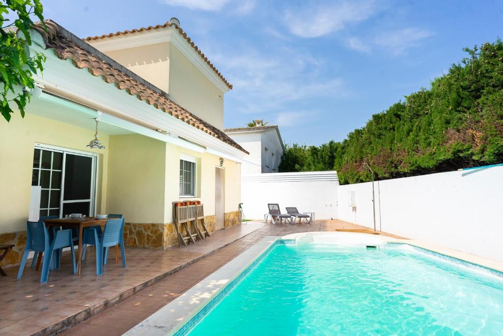 a house with a swimming pool and a table and chairs at Lo Raconet de Júlia in Vinaròs