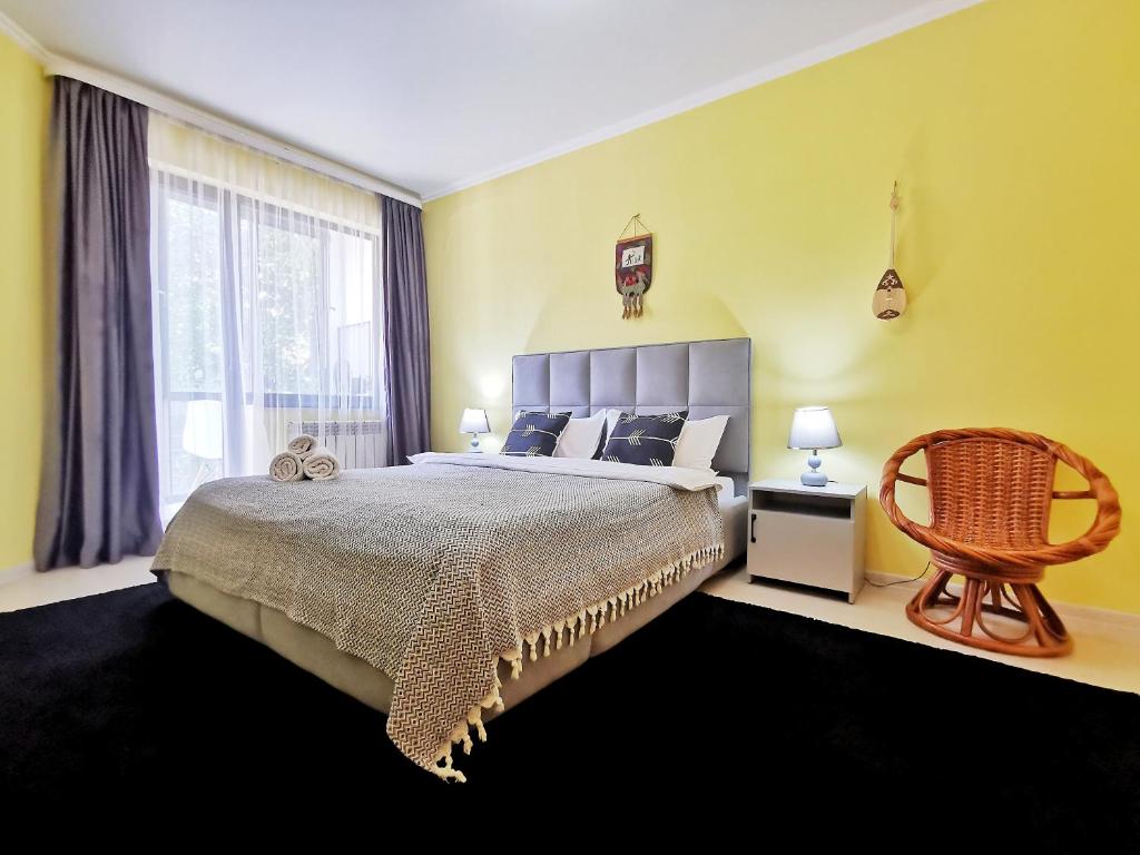 um quarto com uma cama grande e uma cadeira em Апартаменты MOON APARTMENTS - RIVER PARK em Almaty