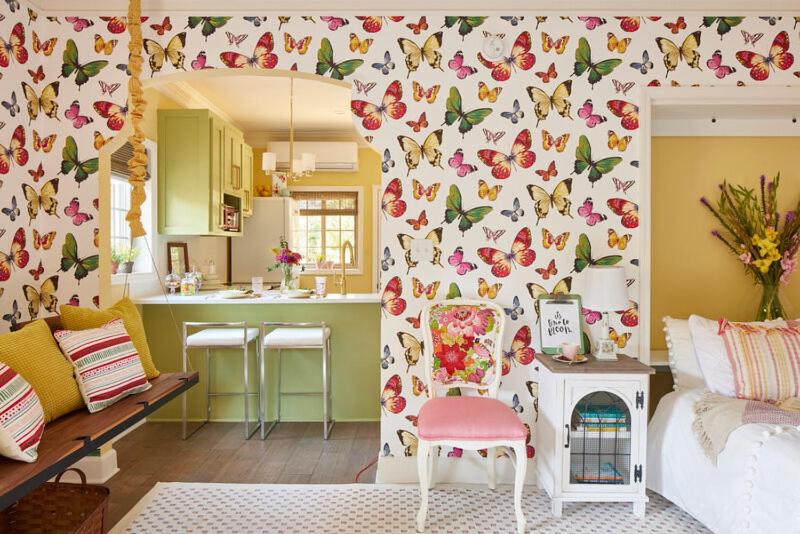 a kitchen and a living room with a wall covered in butterflies at The Villas at Spanish Court in Minden