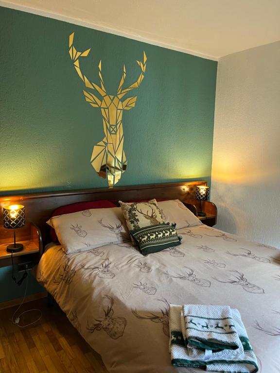 ein Schlafzimmer mit einem Bett mit einem Hirschkopf an der Wand in der Unterkunft Espoire casa sole vda morgex cir 109 in Morgex
