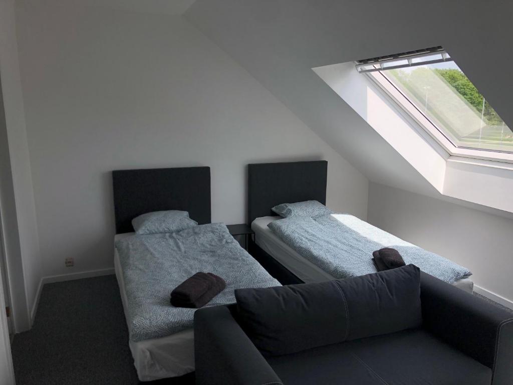 una camera con due letti, un divano e una finestra di Apartment Brussels Airport and NATO OTAN a Machelen