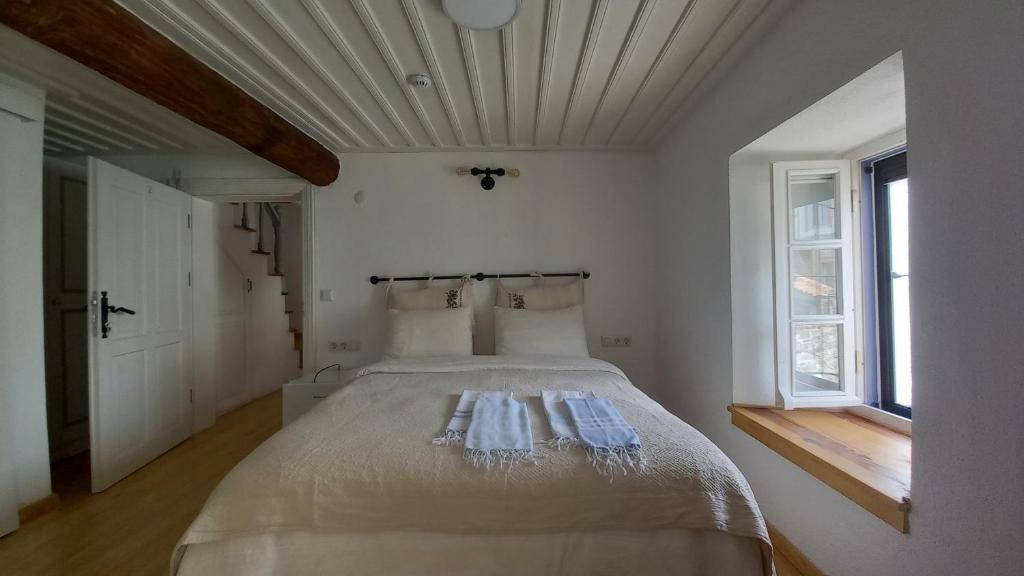 een slaapkamer met een bed in een kamer met een raam bij Nil House Ayvalık in Ayvalık