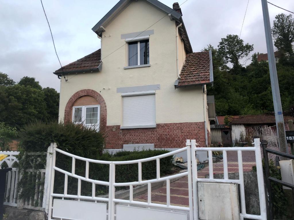 une maison avec une clôture blanche devant elle dans l'établissement Maison de charme proche centre-ville, à Dieppe