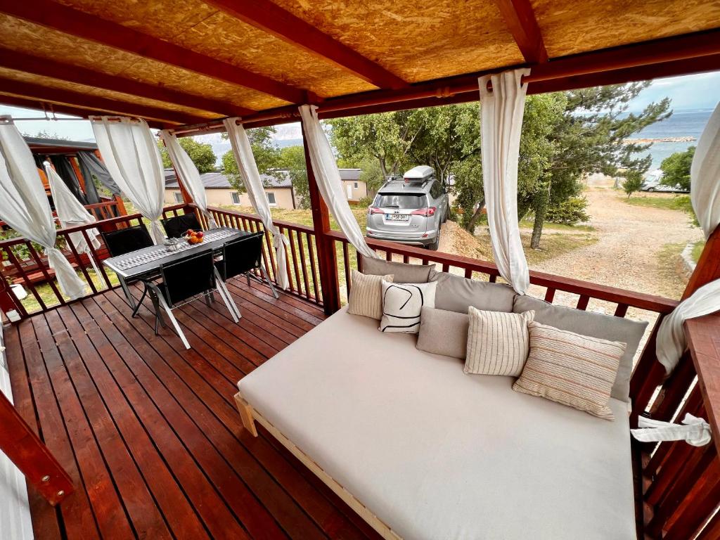 un porche con sofá y escritorio en Mobile home Nebo Luxus, en Klenovica