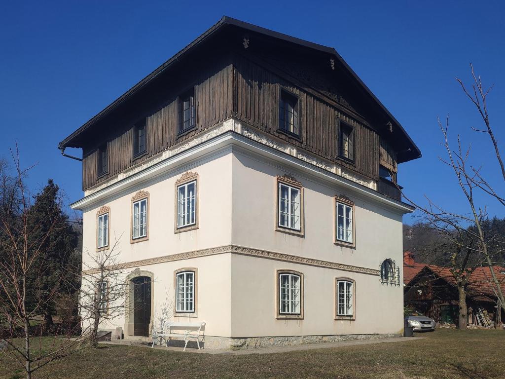 duży biały budynek z drewnianym dachem w obiekcie Apartment Charlie w mieście Kamnik