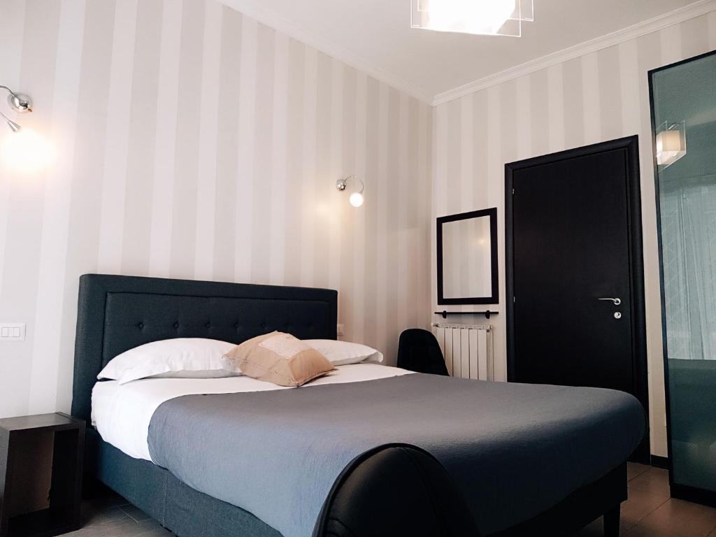 Schlafzimmer mit einem großen Bett mit einem schwarzen Kopfteil in der Unterkunft B&B Il Granello Di Senape in Rom