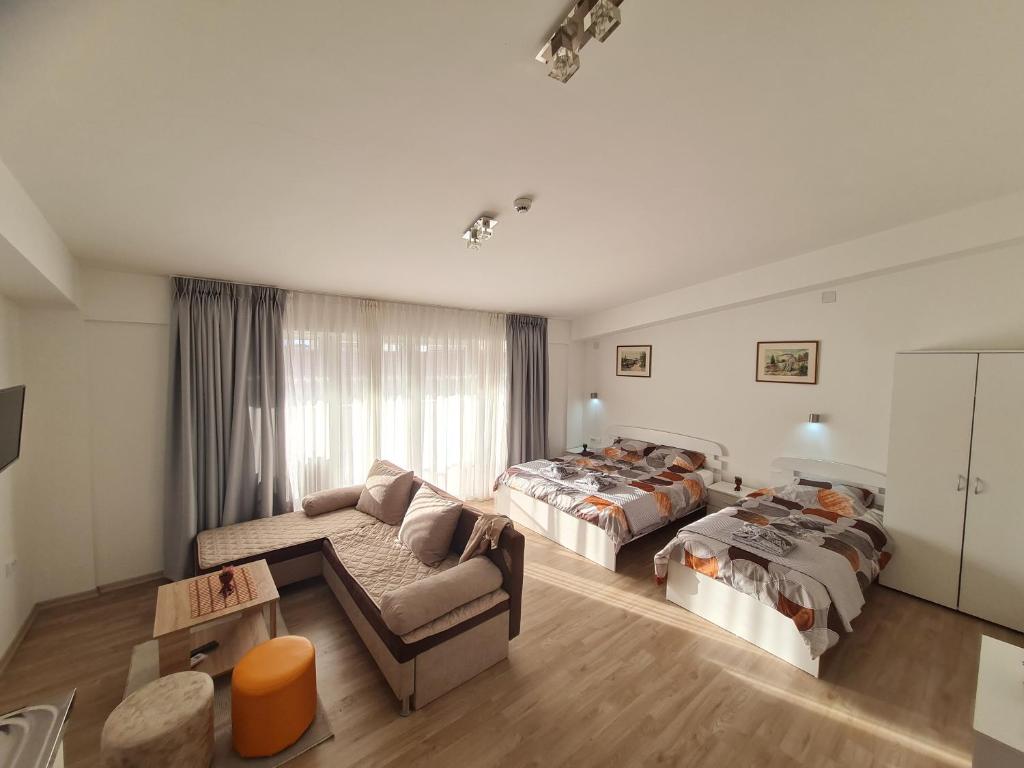 uma sala de estar com duas camas e um sofá em Ohrid Sunlight em Ohrid
