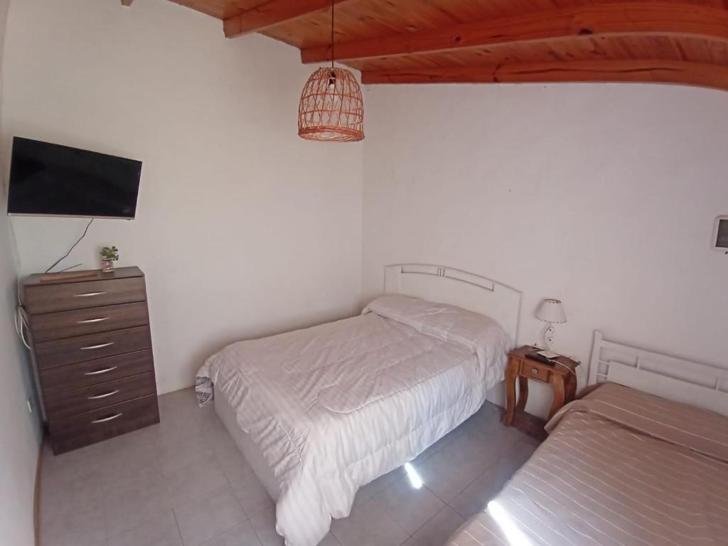 a bedroom with two beds and a flat screen tv at Quinta El Cholito in Luján