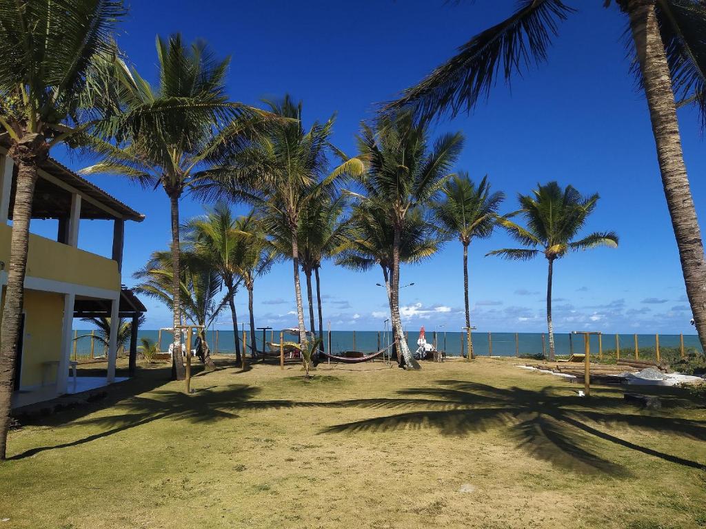 Quintal da Praia في برادو: مجموعة من أشجار النخيل على الشاطئ مع المحيط