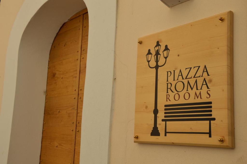 un cartello per una pizzeria roma con panchina di Piazza Roma Rooms a Benevento