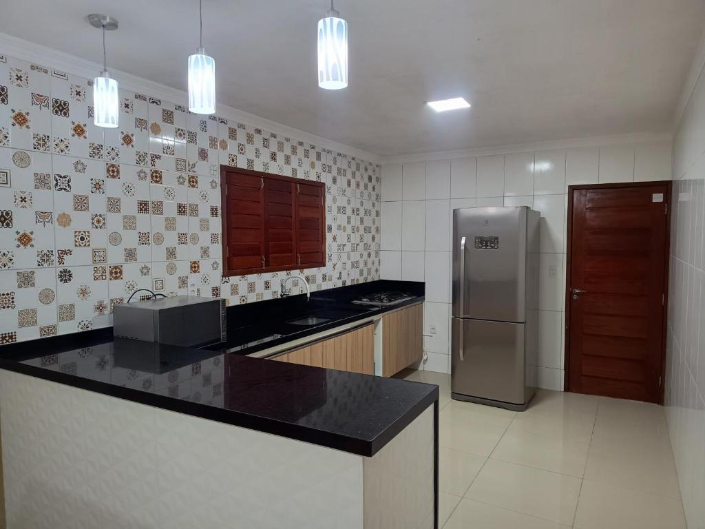 Il comprend une cuisine équipée d'un comptoir et d'un réfrigérateur. dans l'établissement SEU LAR, à Campina Grande