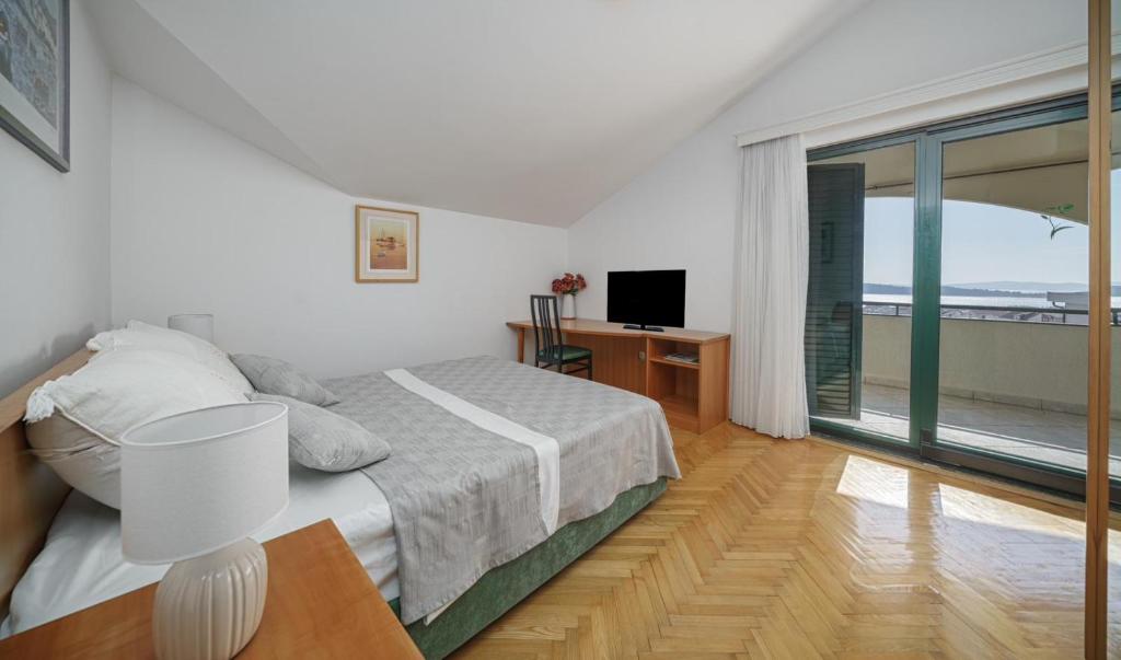 a bedroom with a bed and a large window at Villa David in Vodice