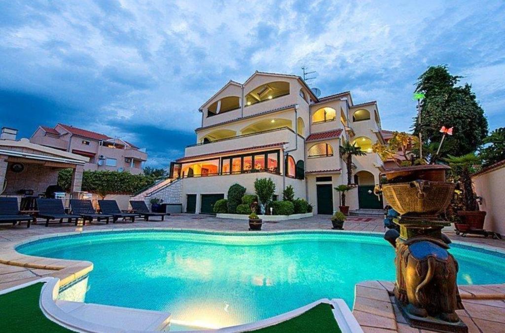 a large house with a swimming pool in front of it at Villa David in Vodice