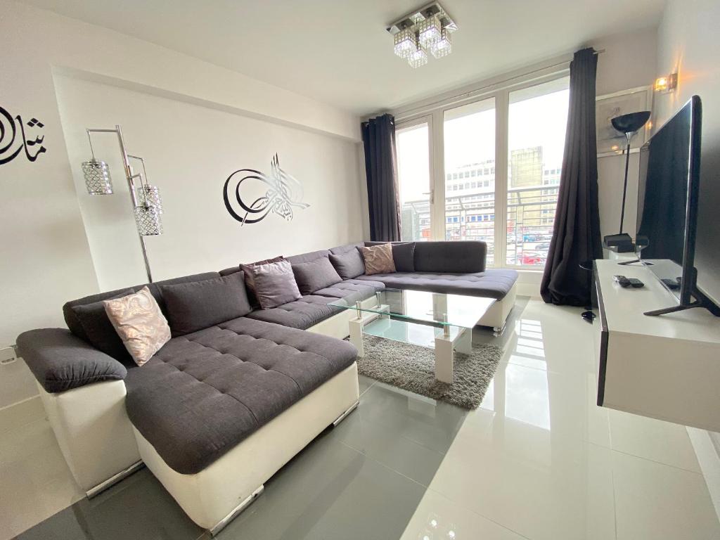 un soggiorno con divano e tavolo in vetro di Contemporary City Centre Apartment in The Aspect a Cardiff