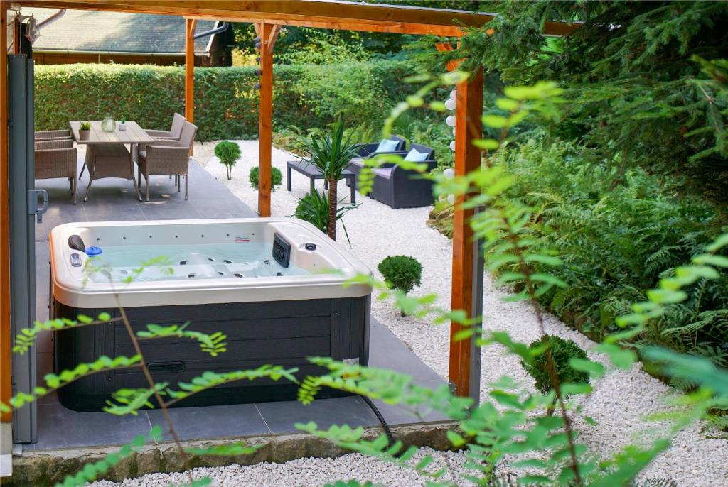 a hot tub in the middle of a garden at Chillout Apartman Noszvaj in Noszvaj