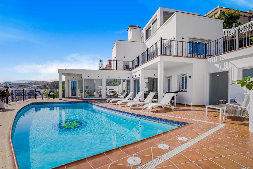 een villa met een zwembad en een huis bij Villa Torremimosas in Fuengirola