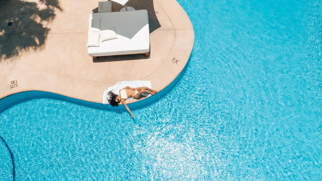an overhead view of a person laying in a pool at Bahia Hotel & Beach House in Cabo San Lucas