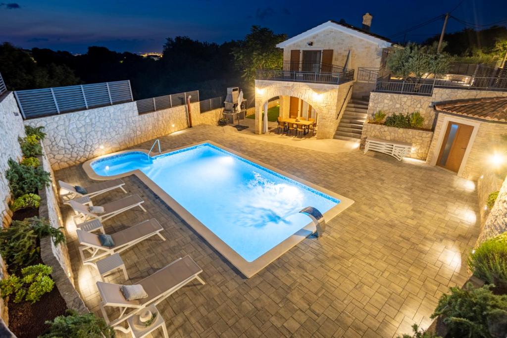 a swimming pool in a backyard at night at Luxury Villa Petros in Malinska