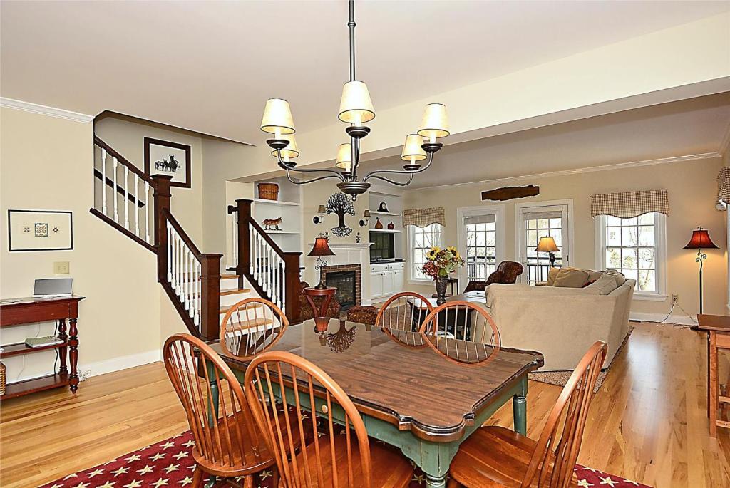 a dining room and living room with a table and chairs at Village Stroll in Stowe