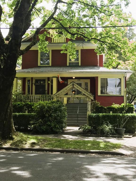 a red house with a tree in front of it at Douglas Guest House in Vancouver