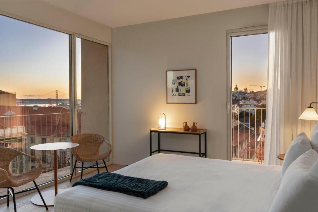 a bedroom with a bed and a window with a view at Pátio do Tijolo in Lisbon