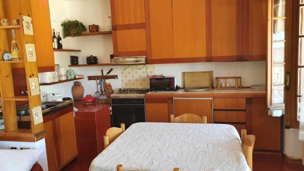 a kitchen with wooden cabinets and a table in it at La Casetta in Codevilla - Roburent in Roa Marenca