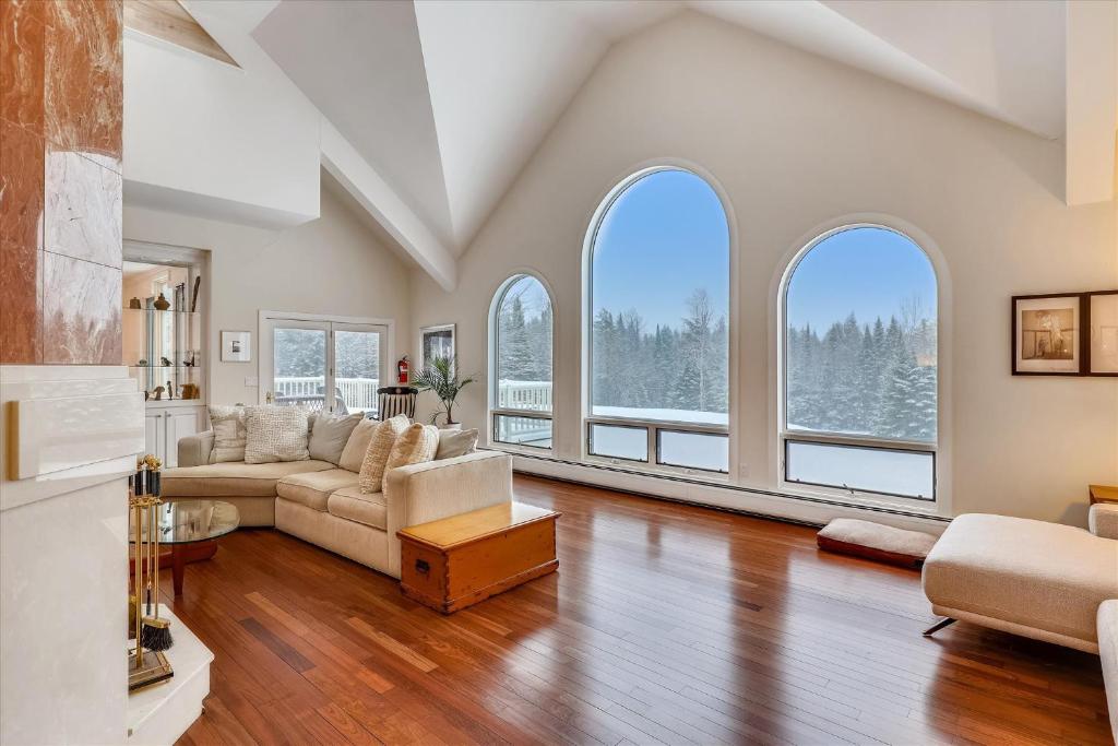 a living room with a couch and large windows at Edson Hill Estate in Stowe
