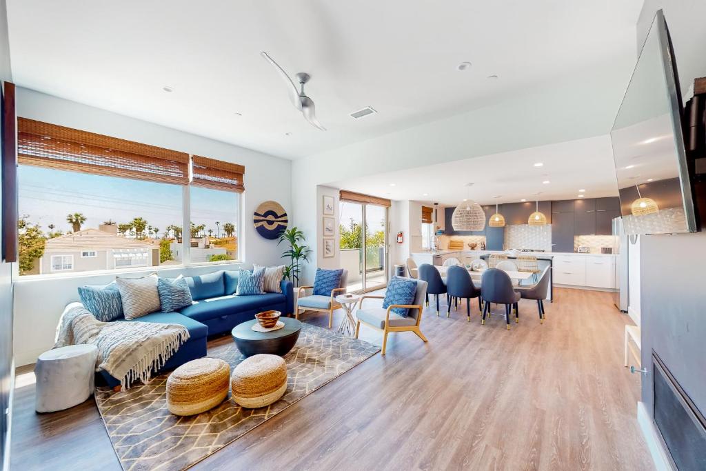 a living room with a blue couch and a table at Seaside Serenity Retreat Inviting condo in Oceanside with rooftop, hot tub, balcony, and ocean views in Oceanside