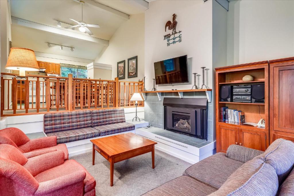 a living room with two couches and a fireplace at Tollhouse 16A in Stowe