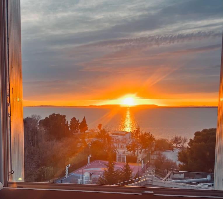 a view of a sunset from a window at T4 jolie vue avec jaccuzzi in Vitrolles