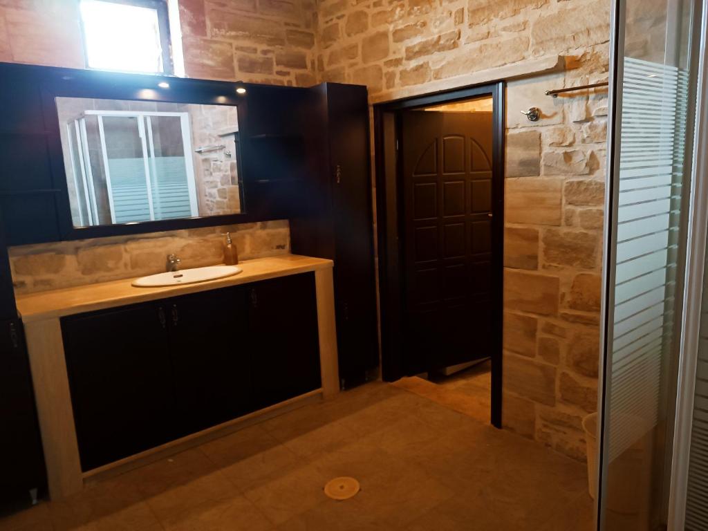 La salle de bains est pourvue d'un lavabo et d'un miroir. dans l'établissement Hephaestus Villa, à Kapparianá