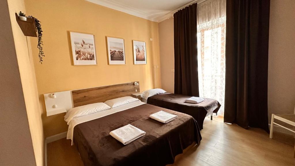 ローマにあるPardis Guest houseのベッド2台と窓が備わるホテルルームです。