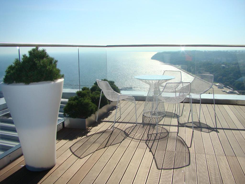 terraza con sillas y mesa en el balcón en Sea Towers Gdynia Pomerania, en Gdynia