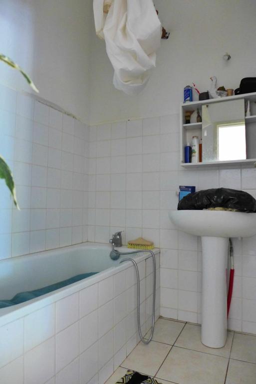 ein Badezimmer mit einer Badewanne und einem Waschbecken in der Unterkunft BUREAUX Appartements LESPARRE MEDOC in Lesparre-Médoc