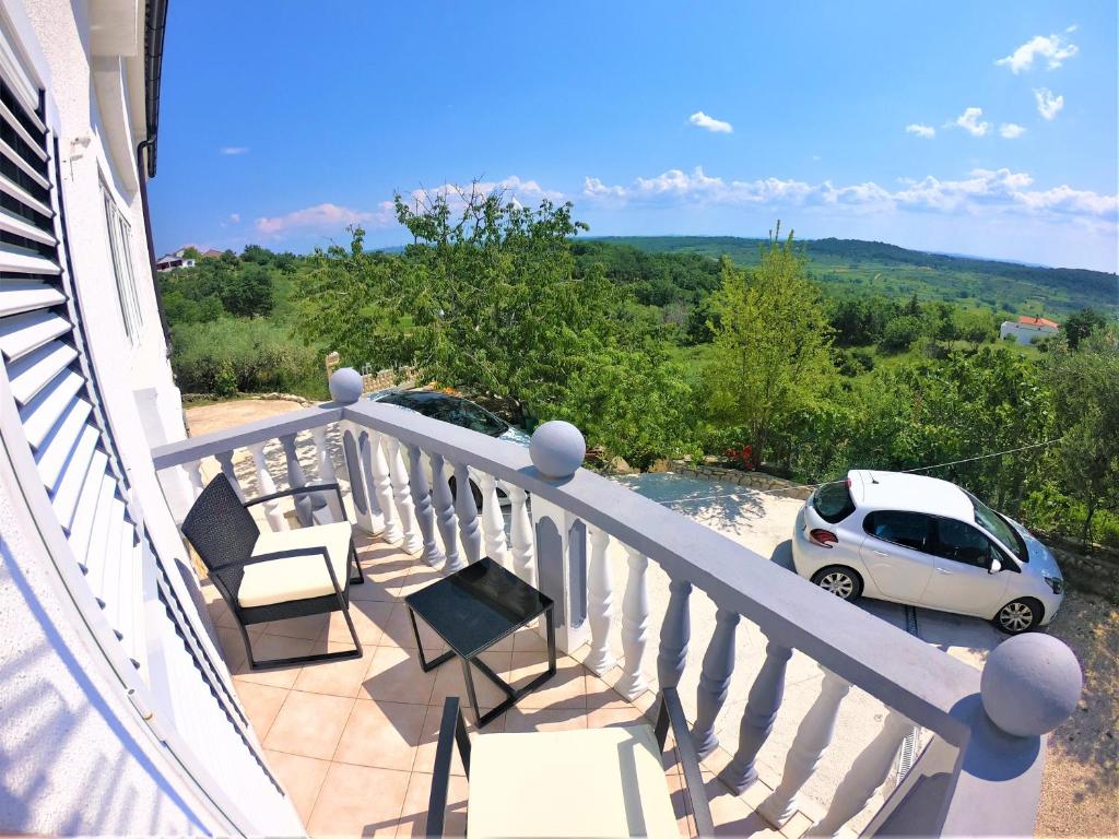 un balcón con sillas y un coche aparcado en él en Apartman Tina, en Ražanac