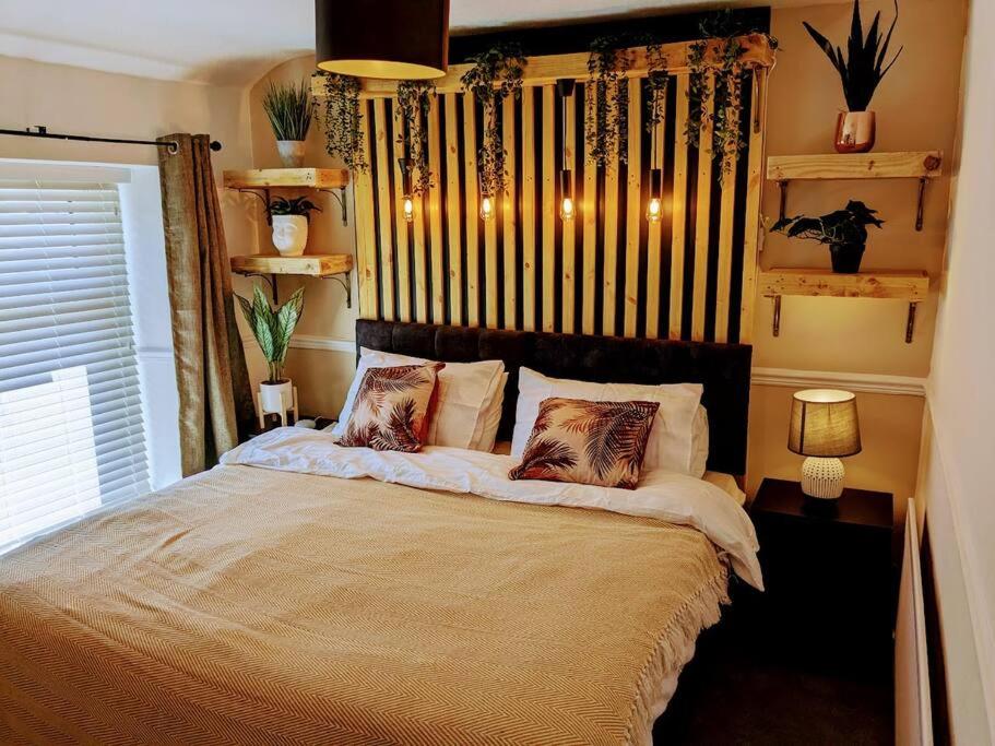 1 dormitorio con 1 cama con 2 almohadas en Stylish & Comfortable House in Swansea, en Morriston