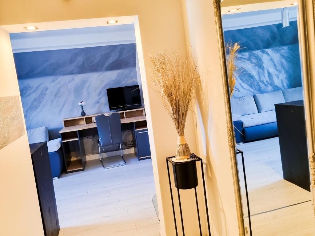 einen Spiegel, der ein Wohnzimmer mit einem blauen Sofa reflektiert in der Unterkunft Da Vinci Appartement in Kapfenberg