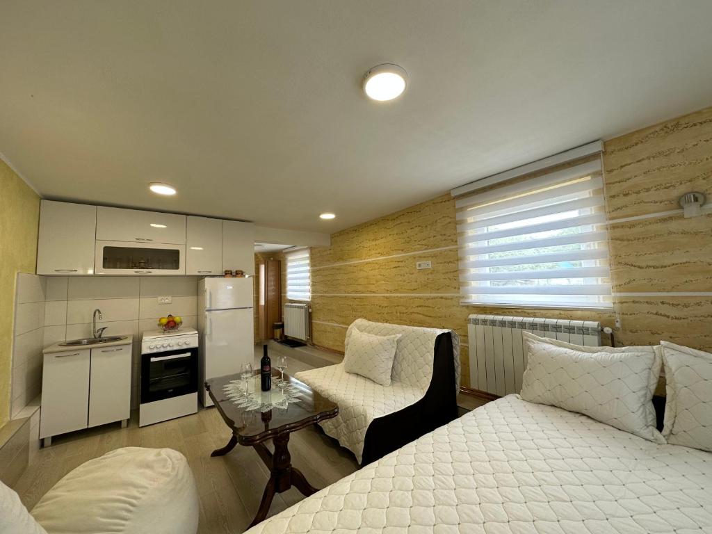 Cette chambre comprend un lit, une table et une cuisine. dans l'établissement Pejovic apartmani Mojkovac, à Mojkovac