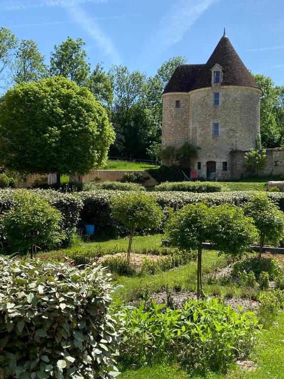 une vieille maison en pierre avec un jardin devant dans l'établissement Tour du manoir de Boiscorde, à Rémalard