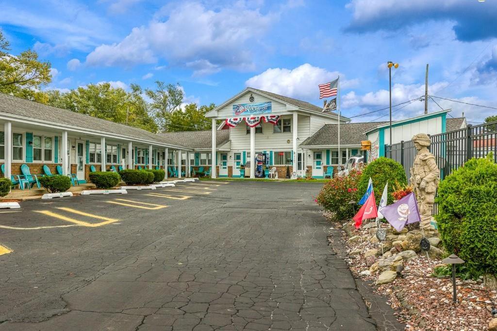 un motel con banderas en el estacionamiento en Riviera Motel, en Erie