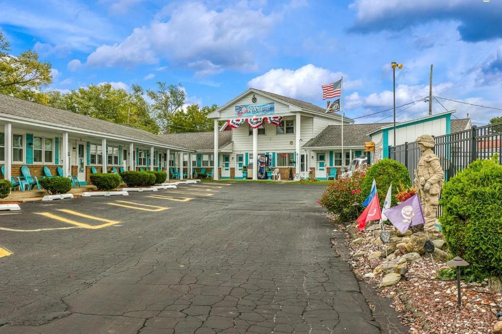 a motel with flags in the parking lot at Riviera Motel in Erie