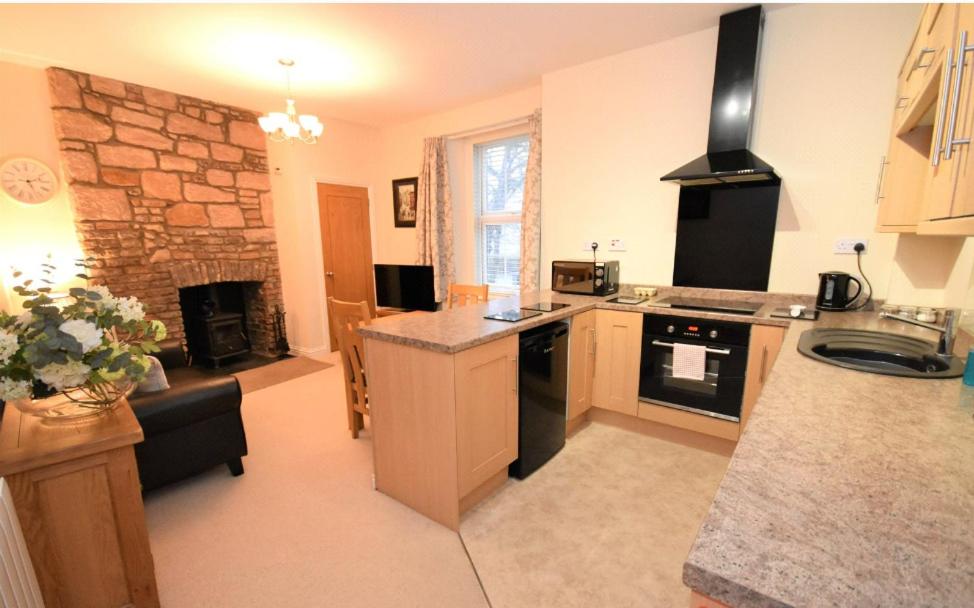 uma cozinha com fogão forno superior ao lado de uma sala de estar em Snug on the Tweed em Berwick-Upon-Tweed