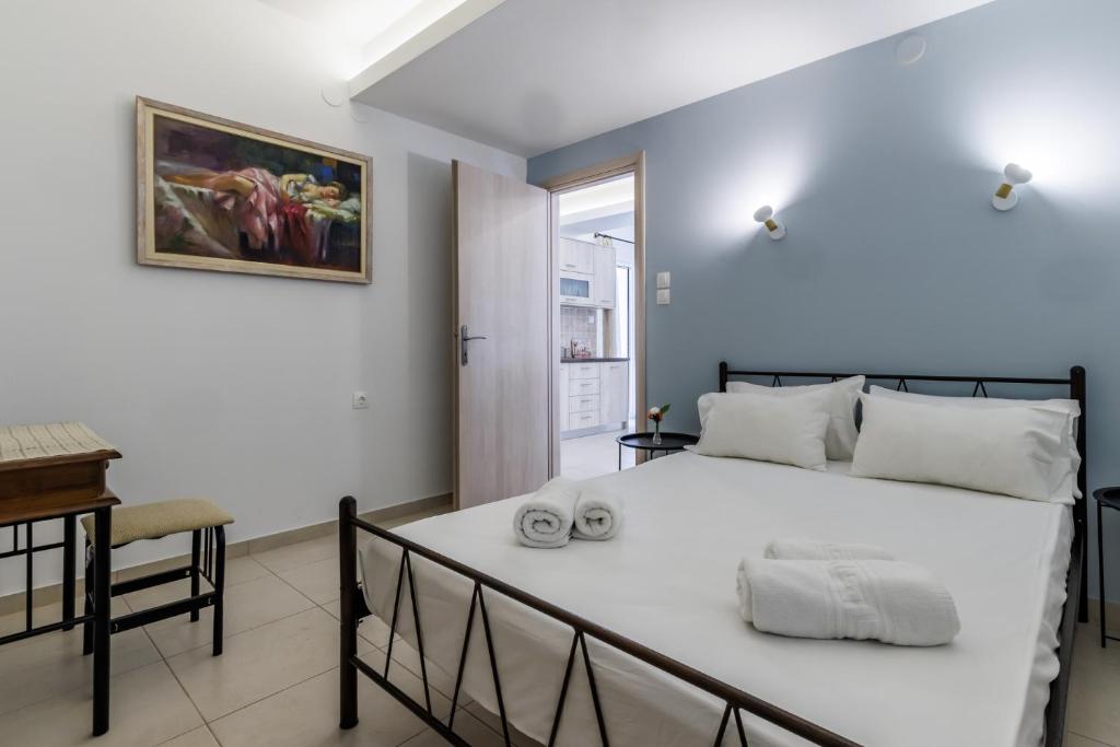 1 dormitorio con 1 cama blanca y 2 toallas en Elios Cozy Apartment, en Neo Klima