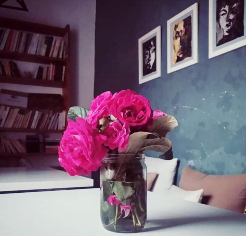 un jarrón lleno de flores rosas sentado en una mesa en Ketama trikital, en Tlata Ketama