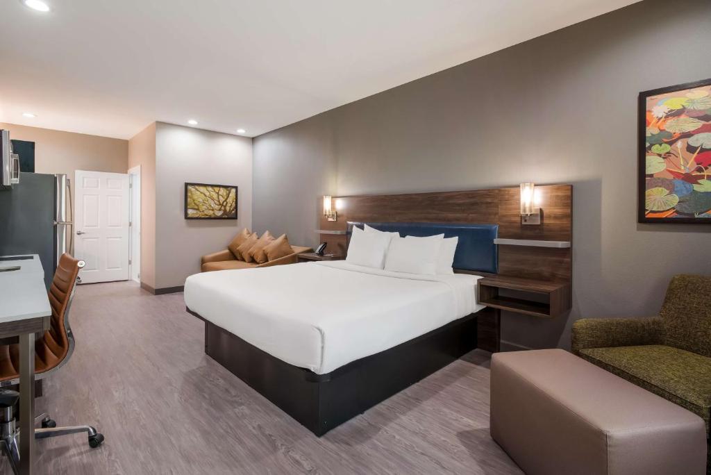 a hotel room with a large bed and a desk at Best Western La Place Inn in Laplace