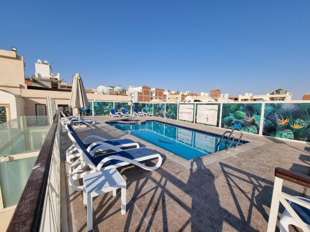 un balcone con sedie e una piscina in un edificio di Lilly City Center Hostel a Hurghada