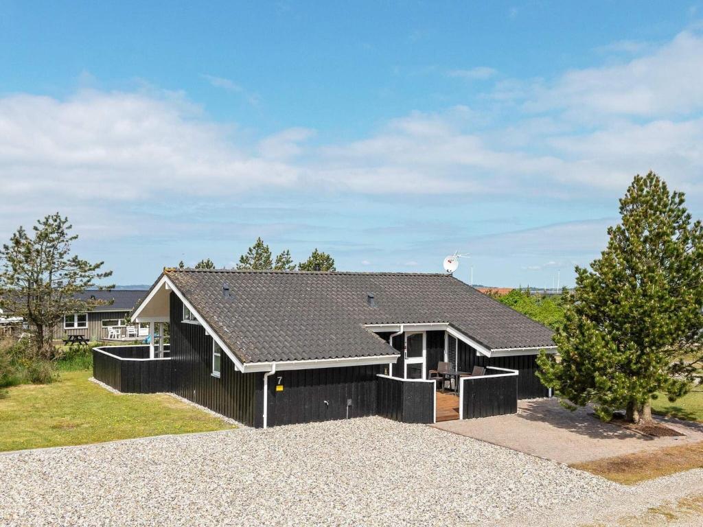 uma casa preta com um telhado preto em Holiday home Løgstør XXIV em Løgsted