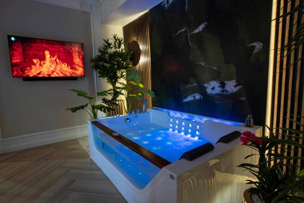 a hot tub in a living room with a fireplace at Aparthotel ZATOR Retro 66 jacuzzi in Zator