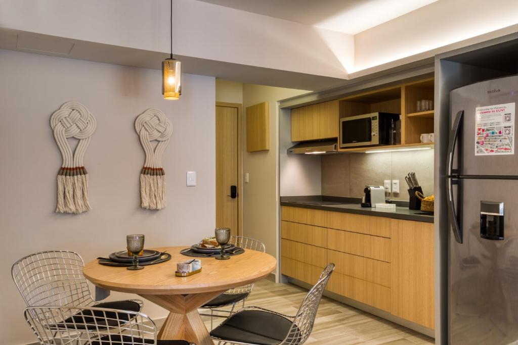 A dining nook beside a fully equipped kitchenette with a large refrigerator.